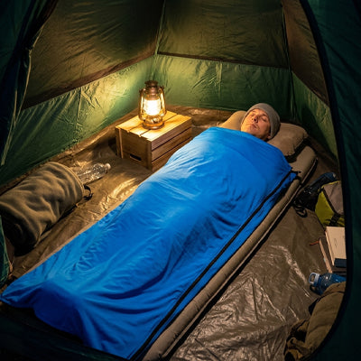 homme dans sac de couchage bleu